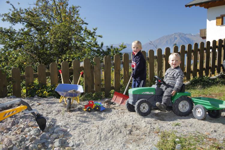 Sandkasten mit Traktor und Sandspielzeug